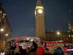 View of Big Ben lit up at night from a tourist bus