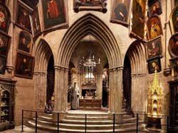 A room with vaulted archways full of portraits