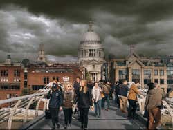 A bridge full of people under a dark cloudy sky